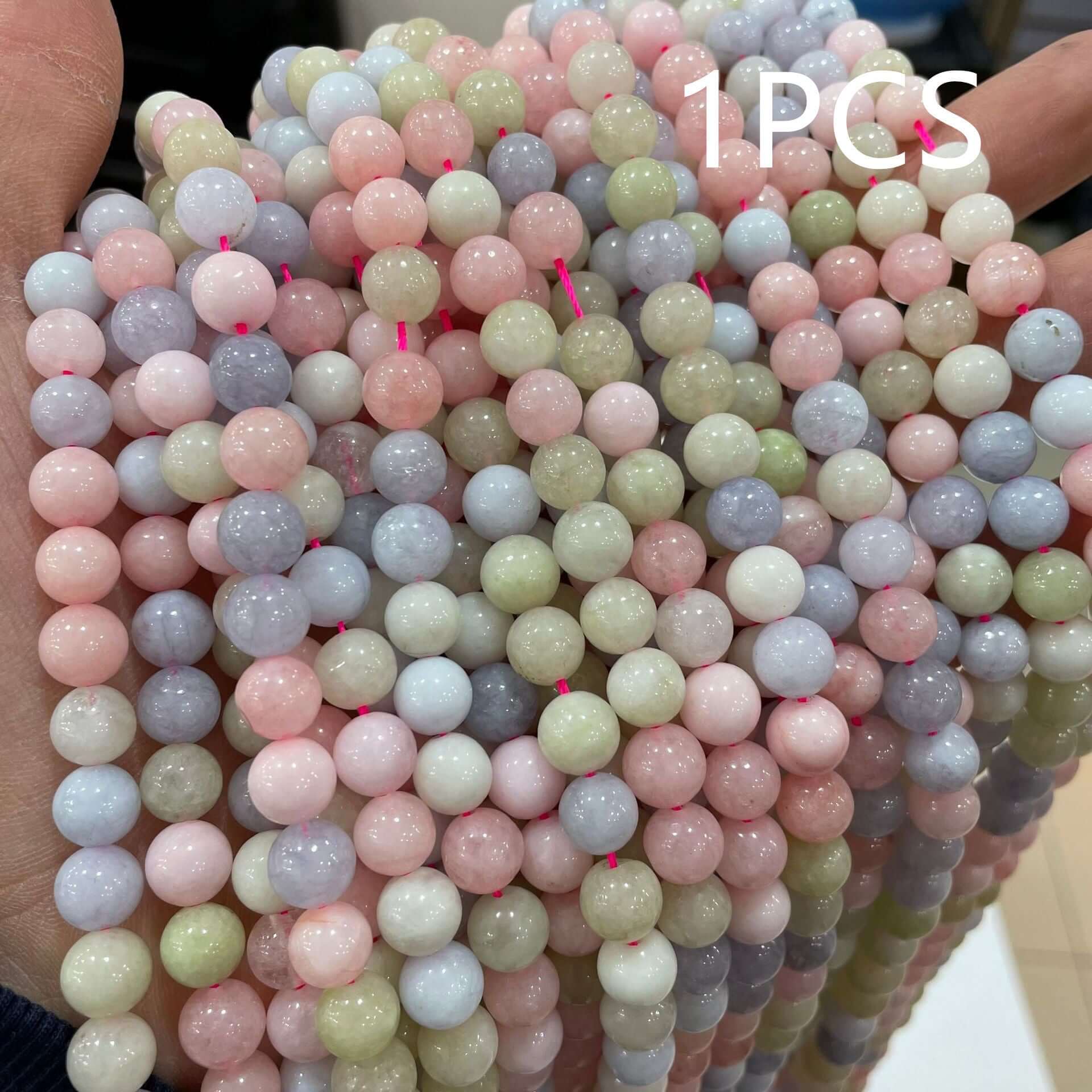 Hand holding natural morganite loose beads in assorted colors for DIY handmade jewelry projects.