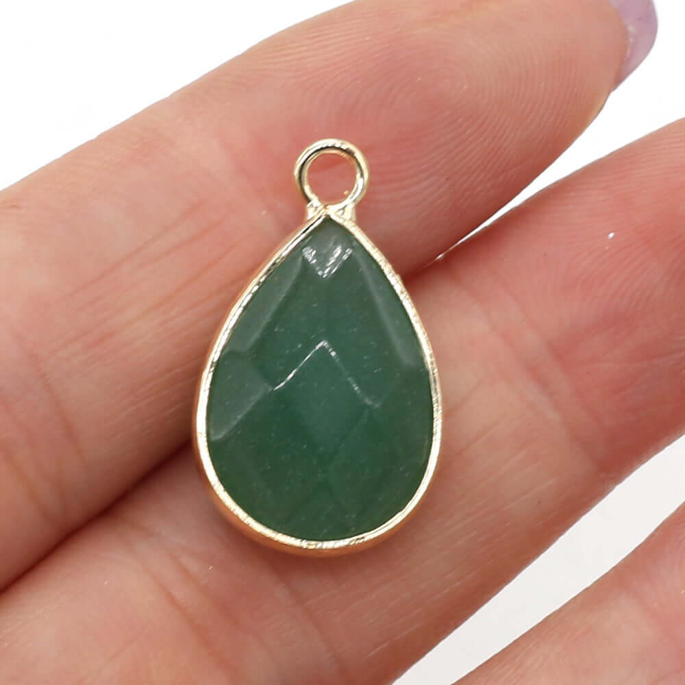 Handmade drop-shaped green Dongling jade pendant held in hand with gold trim, perfect for DIY jewelry projects.