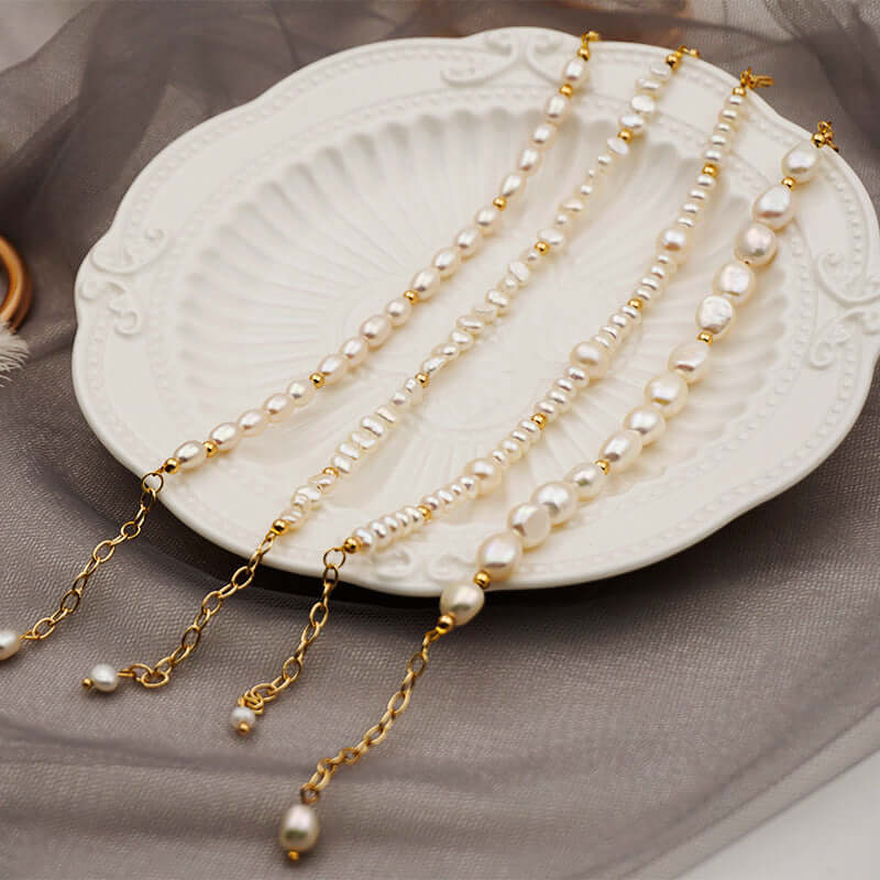 Elegant handmade baroque pearl jewelry displayed on a decorative plate, showcasing natural freshwater pearls and gold accents.